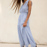Woman wearing a blue striped dress against a neutral background
