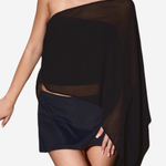 A woman modeling a black one-shoulder sheer wrap top with a matching black mini skirt against a plain light gray background.