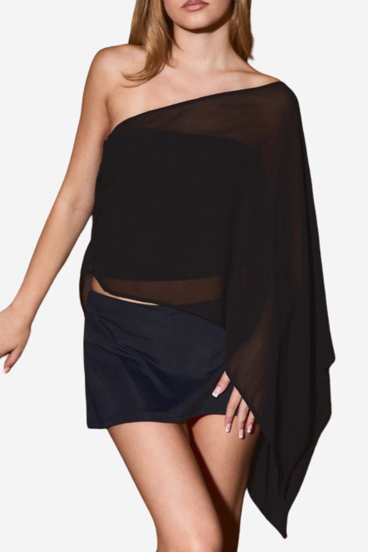 A woman modeling a black one-shoulder sheer wrap top with a matching black mini skirt against a plain light gray background.