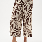 Zebra print pants worn by a person on a white background