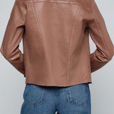 Model wearing a light-wash slim-fit denim jacket with raw hem detailing and a button-front design.