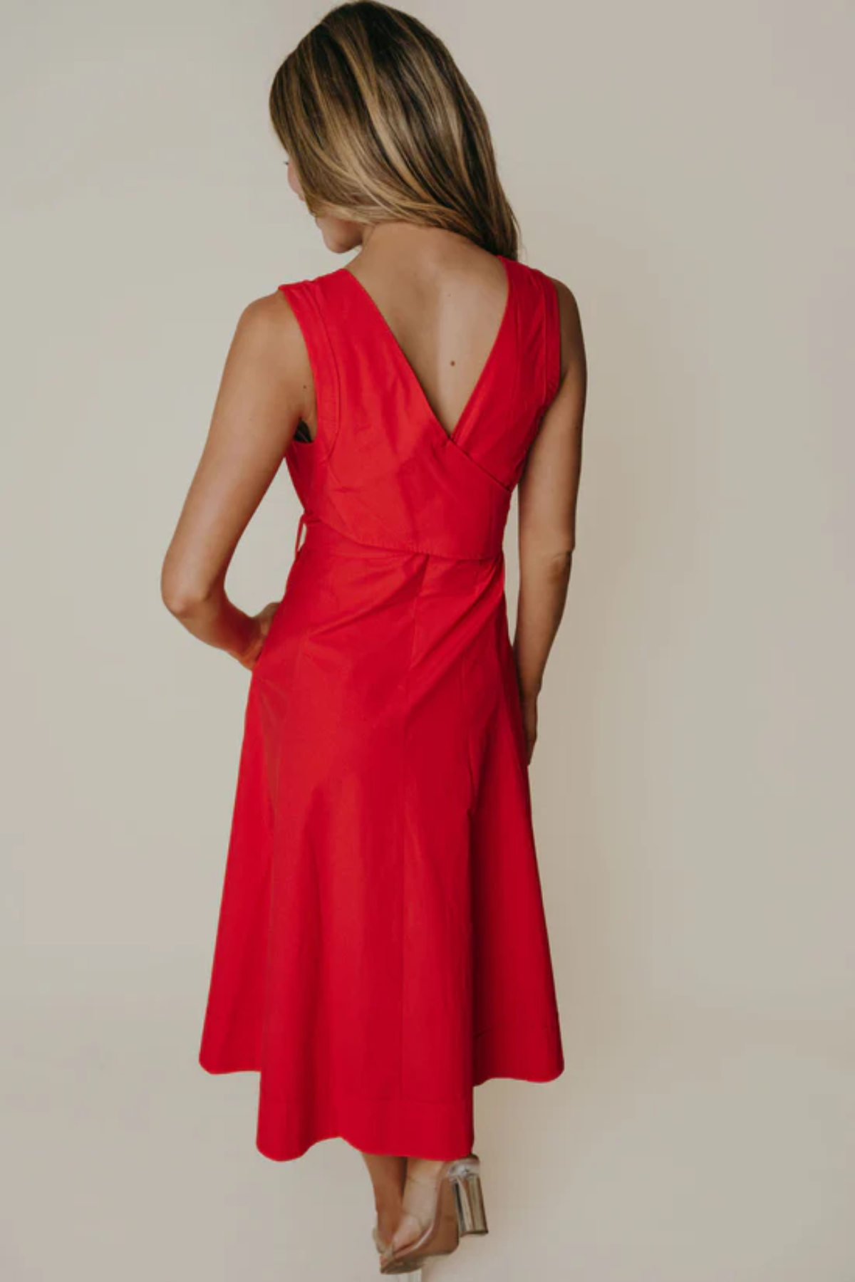 Red dress with a V-neckline on a plain background