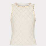 An off-white sleeveless knit top with a gold geometric diamond pattern and gold trim along the shoulder edges, shown against a light gray background.