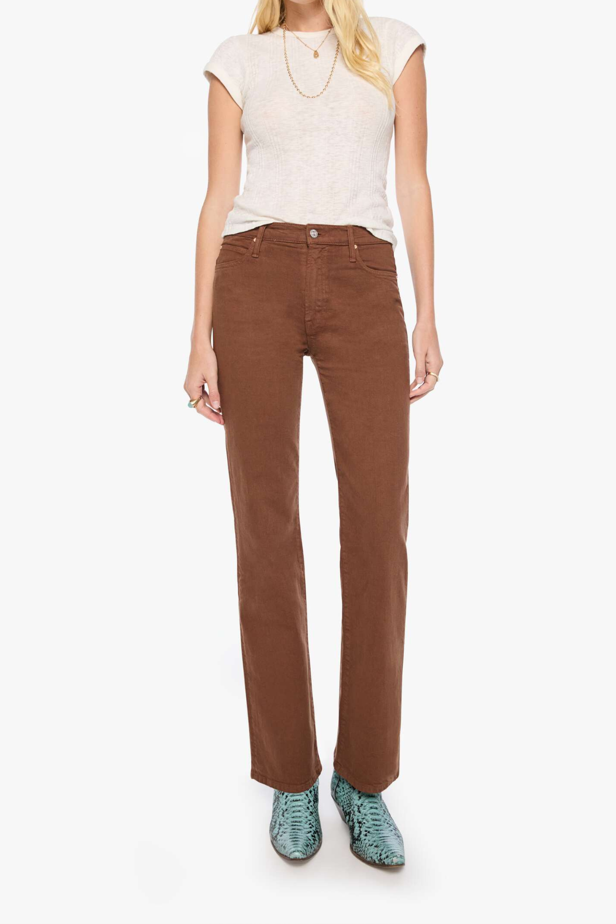 A model wearing brown straight-leg corduroy pants, a light beige short-sleeve knit top, and green snakeskin-patterned shoes, standing against a plain white background.