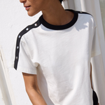 Woman wearing a white t-shirt with black accents against a white background