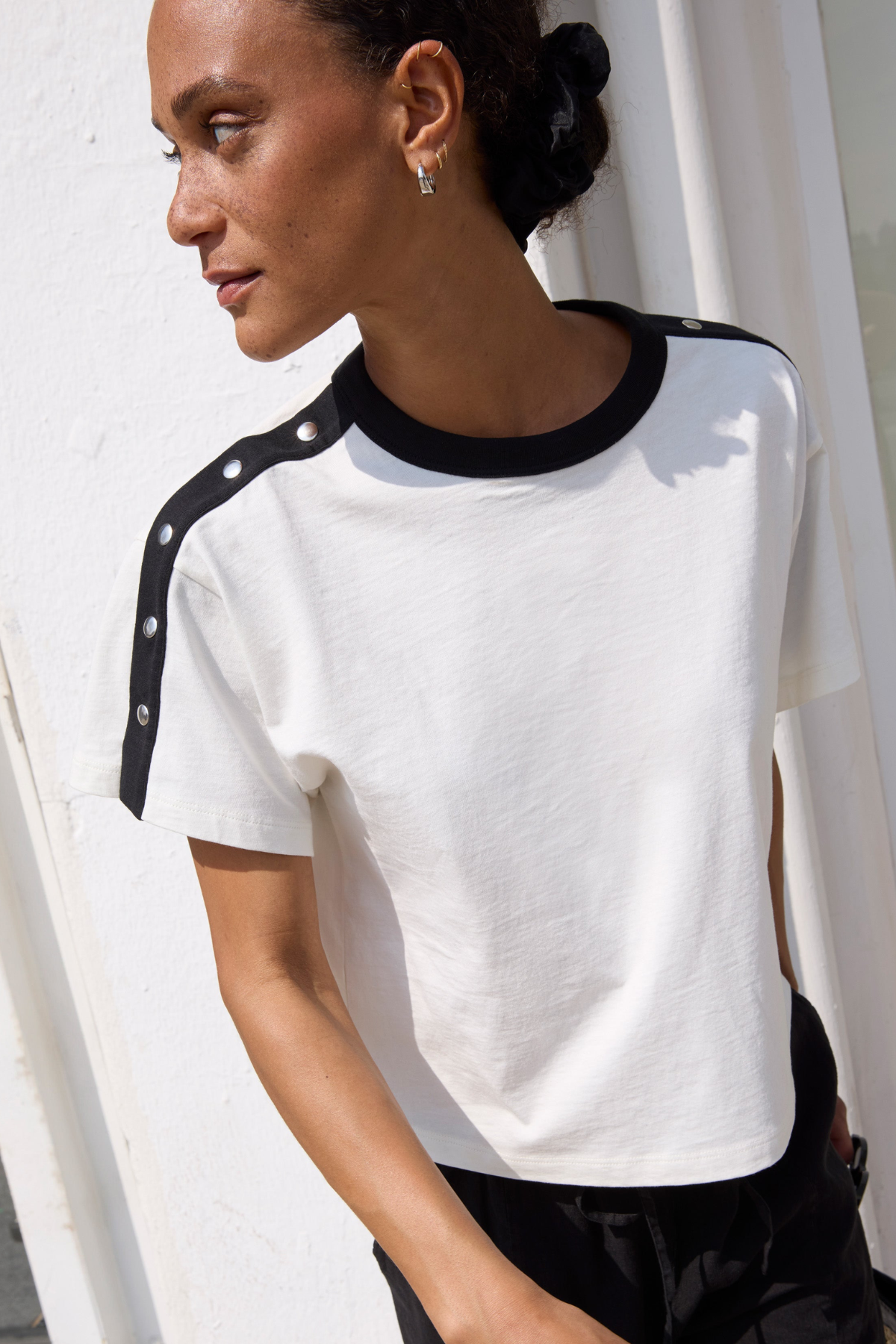 Woman wearing a white t-shirt with black accents against a white background