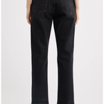 Rear view of a person wearing black cropped jeans with a straight-leg fit, paired with black pointed-toe heels against a light gray studio background.