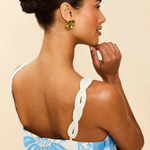 Woman wearing a blue floral dress with a beige background