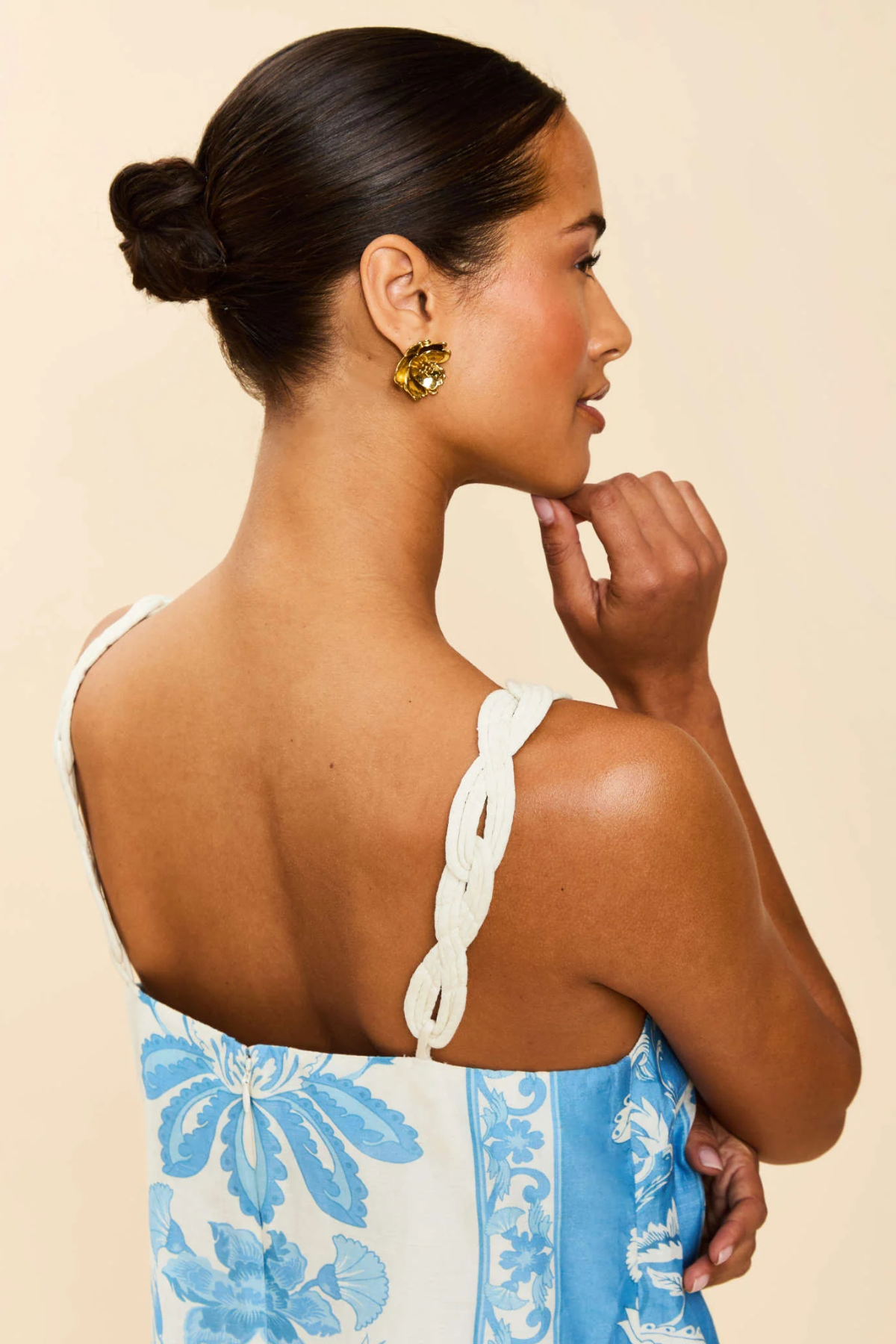 Woman wearing a blue floral dress with a beige background