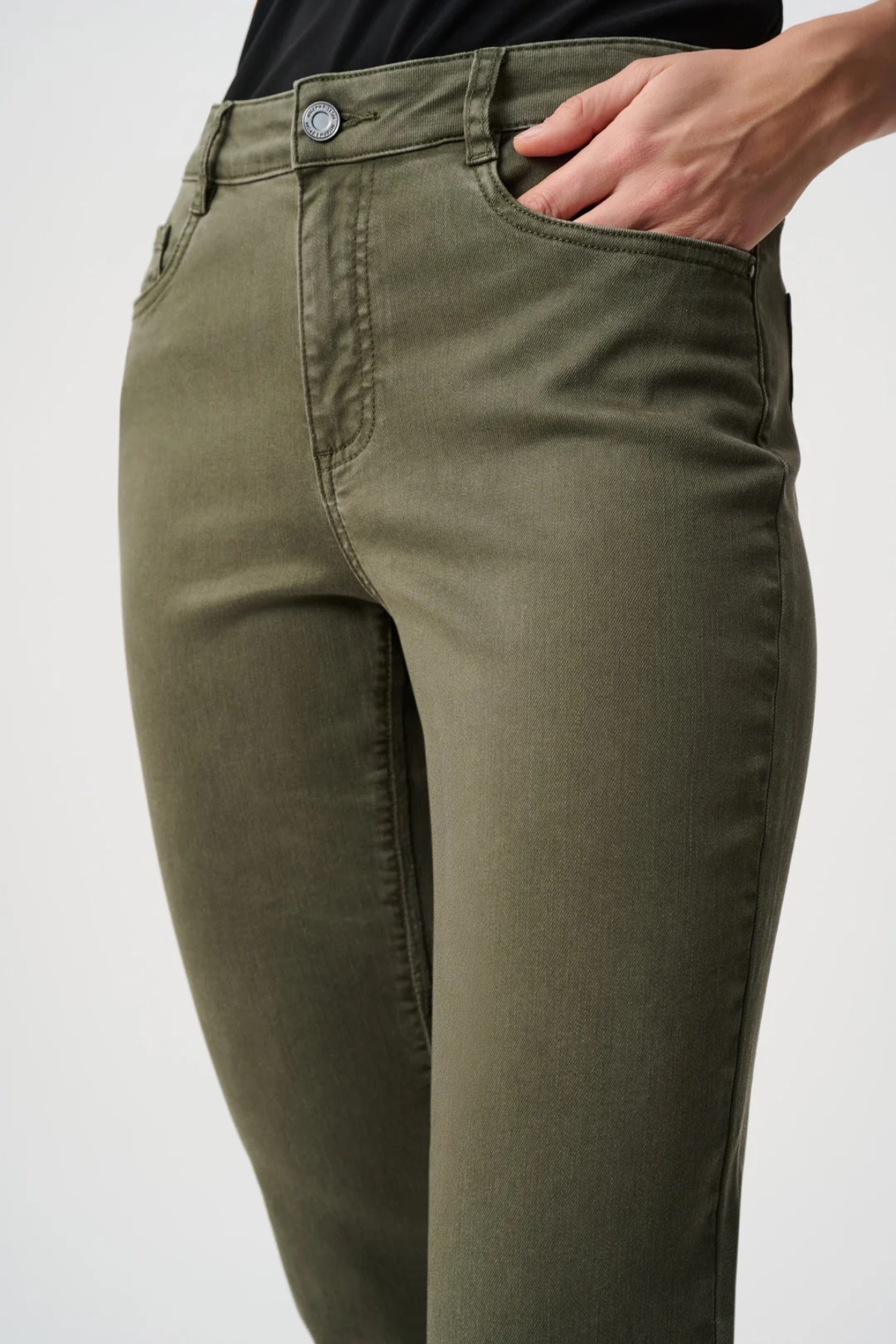 Olive green pants worn by a person on a white background