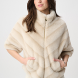 Woman wearing a cream-colored fur vest on a white background