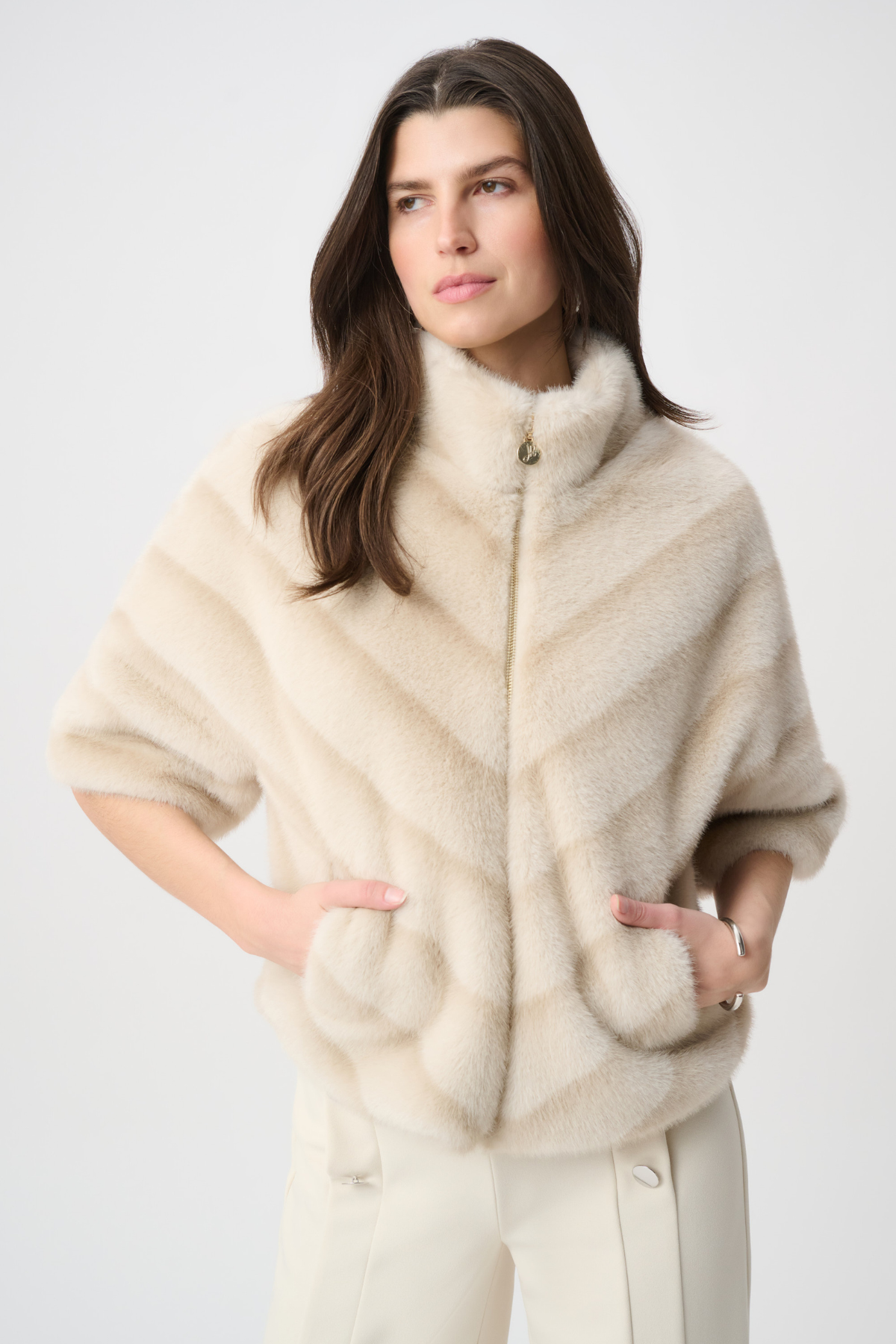 Woman wearing a cream-colored fur vest on a white background