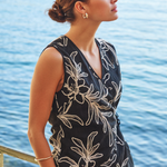 Woman wearing a black floral top by a body of water