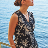 Woman wearing a black floral top by a body of water