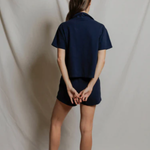 Person wearing a navy blue outfit against a plain background