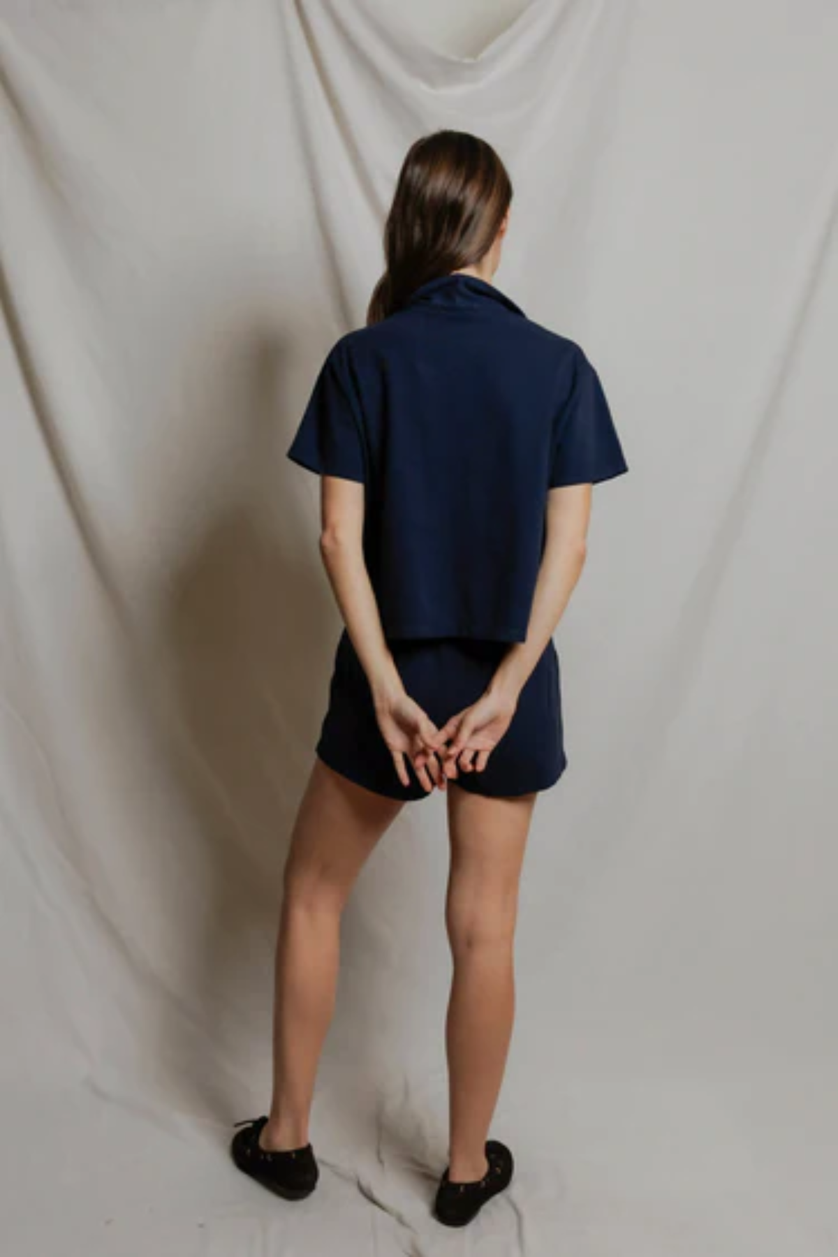 Person wearing a navy blue outfit against a plain background