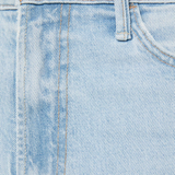 Close-up of light blue denim jeans with a brand label.