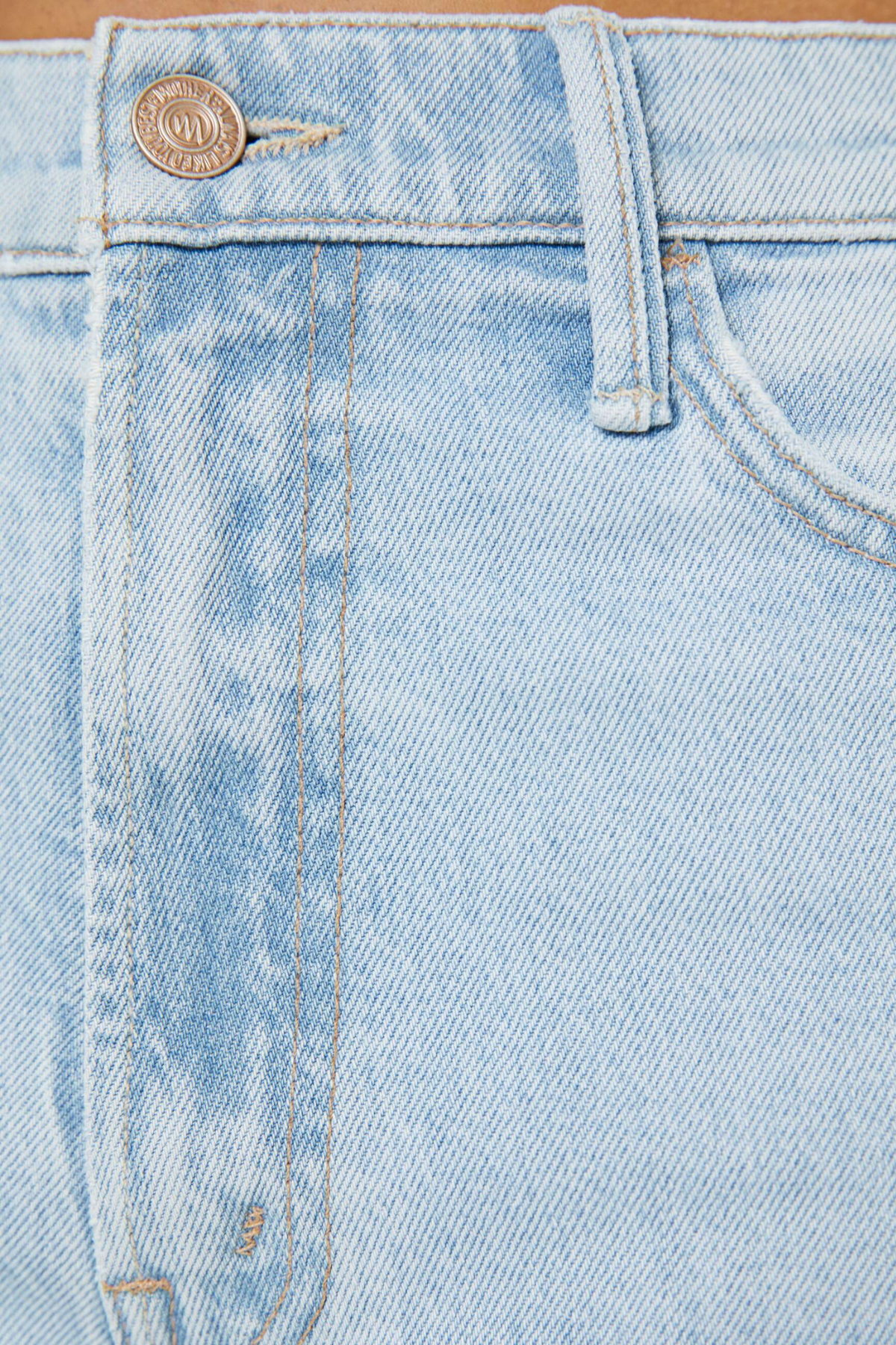 Close-up of light blue denim jeans with a brand label.