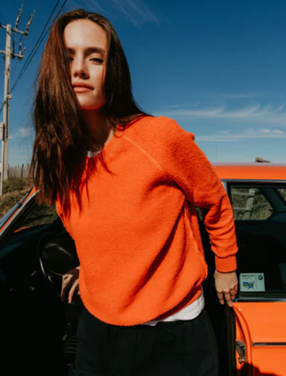 woman in orange sweatshirt outside 