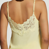 Yellow lace-trimmed camisole worn by a model on a plain background