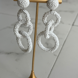 white linked drop earrings with three open circular shapes in a contemporary statement silhouette.