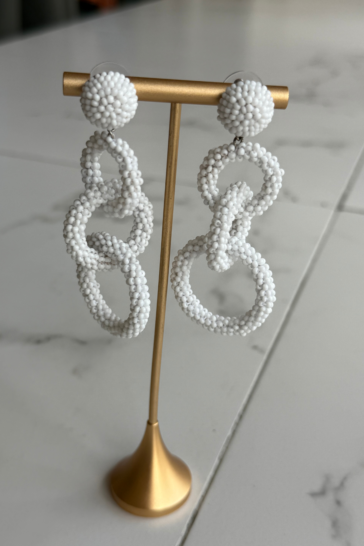 white linked drop earrings with three open circular shapes in a contemporary statement silhouette.