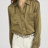 Model wearing an olive green utility button-front shirt with chest pockets and long sleeves.