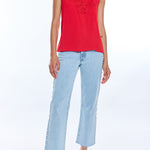 Woman wearing a red sleeveless top and light blue jeans on a white background