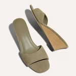 Pair of green suede sandals on a white background