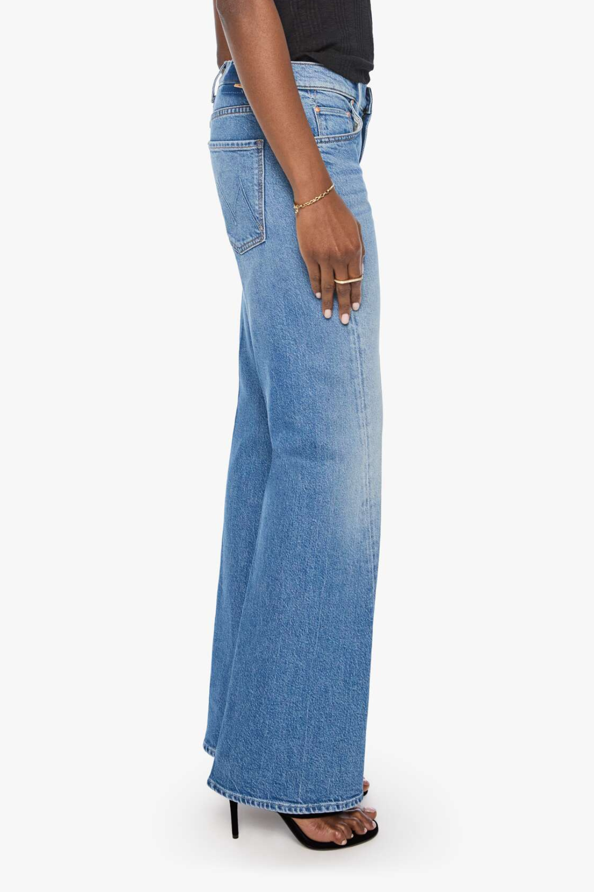 Model wearing light-wash denim jeans with twisted seam detailing and a relaxed straight-leg fit.