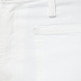 Close-up of a white denim pocket with a brand label.