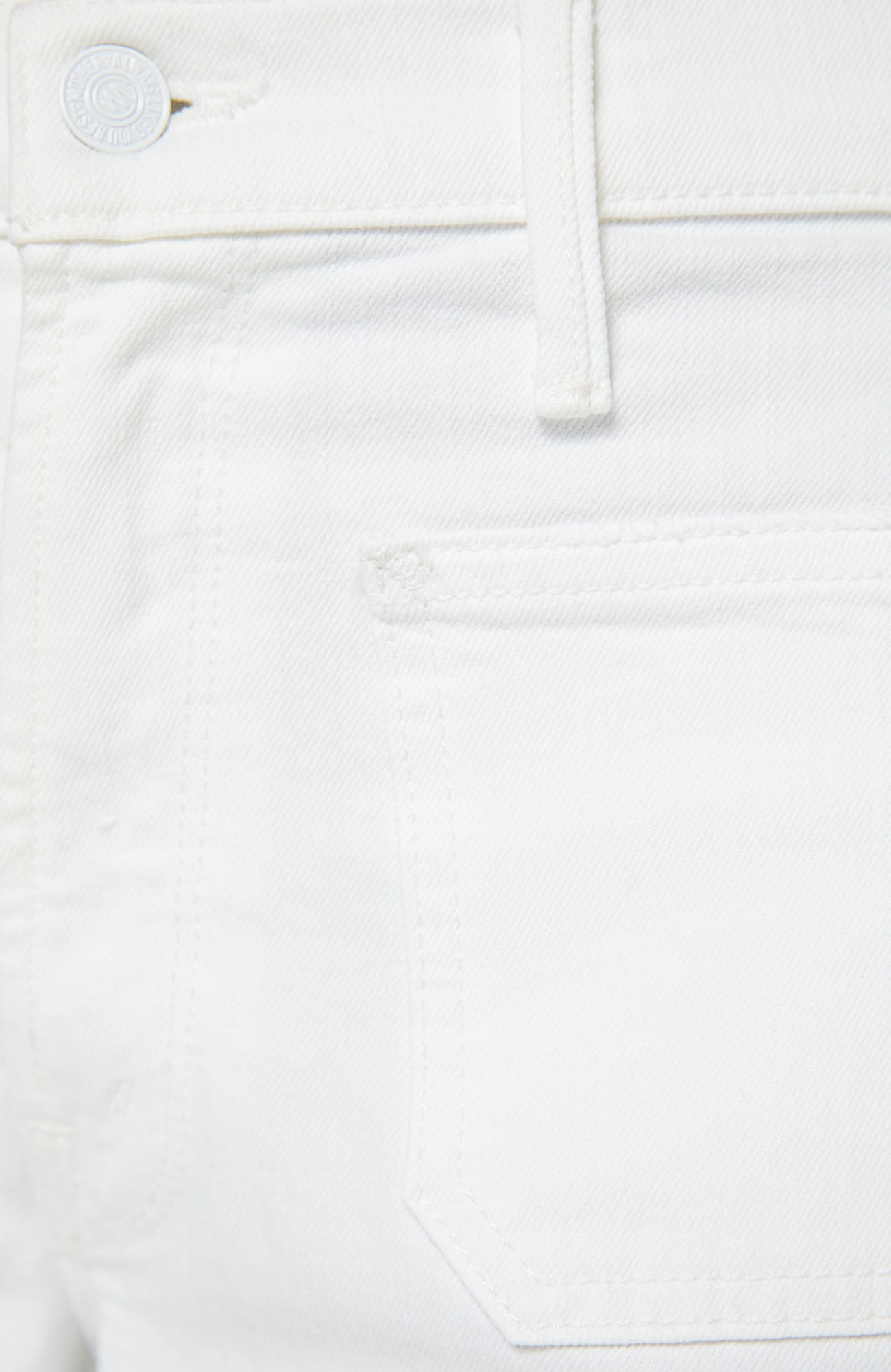 Close-up of a white denim pocket with a brand label.