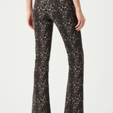A model shown from the back wearing high-waisted leopard-print flare pants in brown and beige, paired with a black top and black pointed-toe heels.