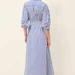 Woman wearing a blue and white striped dress on a plain background