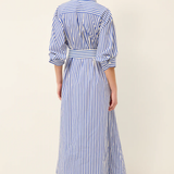Woman wearing a blue and white striped dress on a plain background