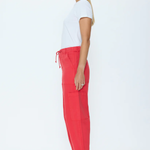 Woman wearing a white t-shirt and red pants on a white background