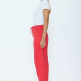 Woman wearing a white t-shirt and red pants on a white background
