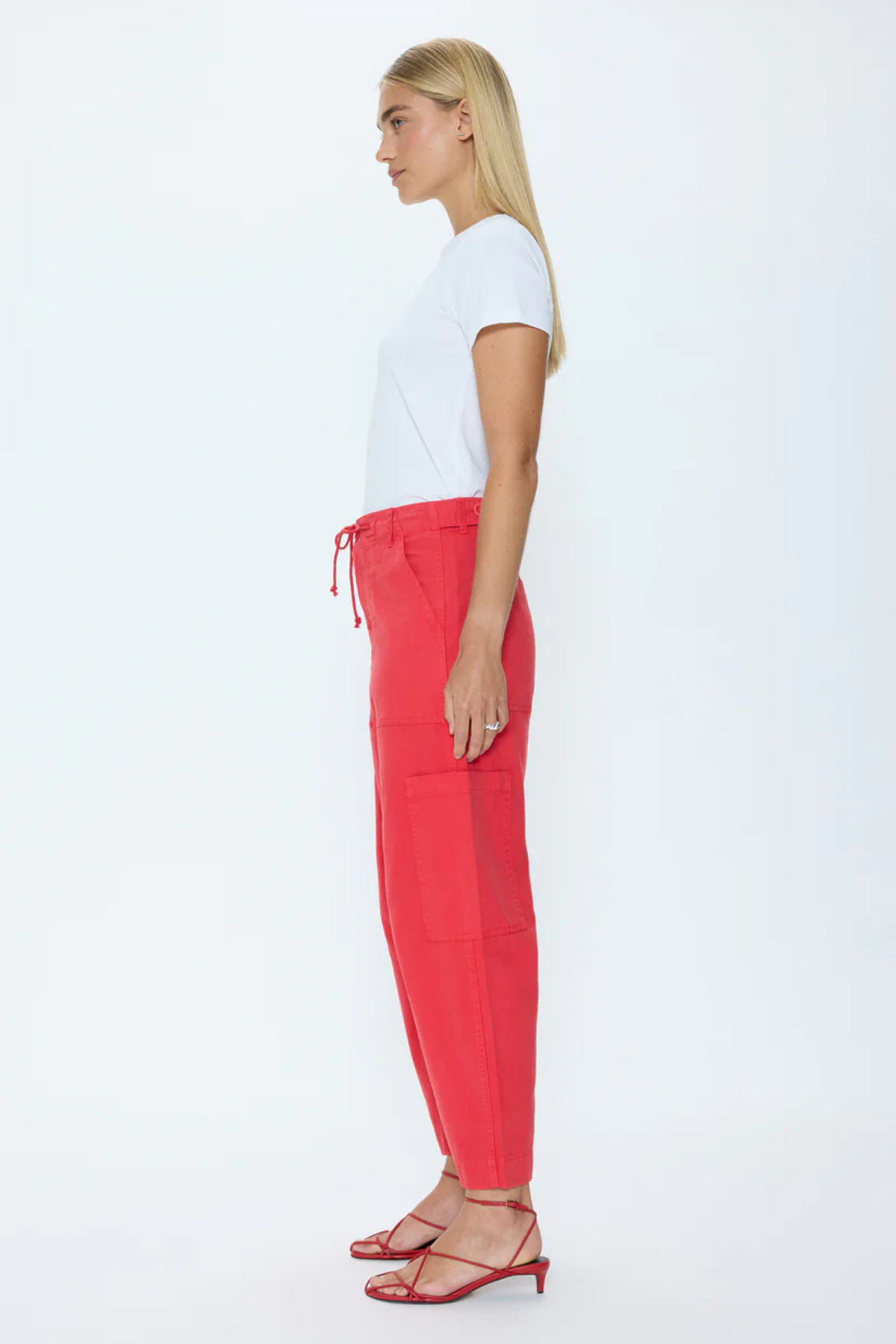 Woman wearing a white t-shirt and red pants on a white background