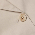 Close-up of a beige fabric with a button on a garment