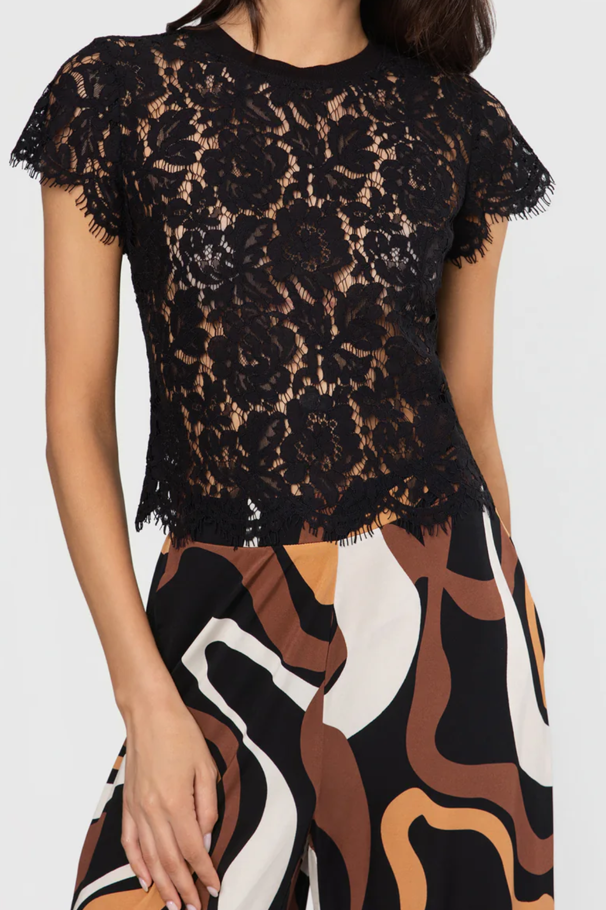 Black lace top worn by a person with a white background