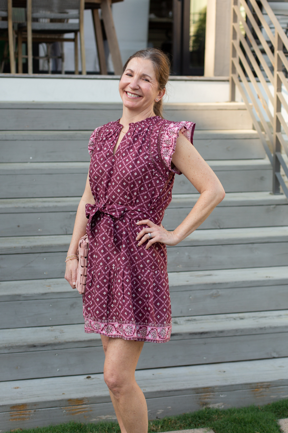 Woman in a patterned dress standing on outdoor steps