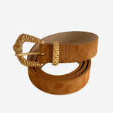 A tan suede belt with a textured gold-tone buckle and matching gold-tone keeper, coiled on a light gray background.