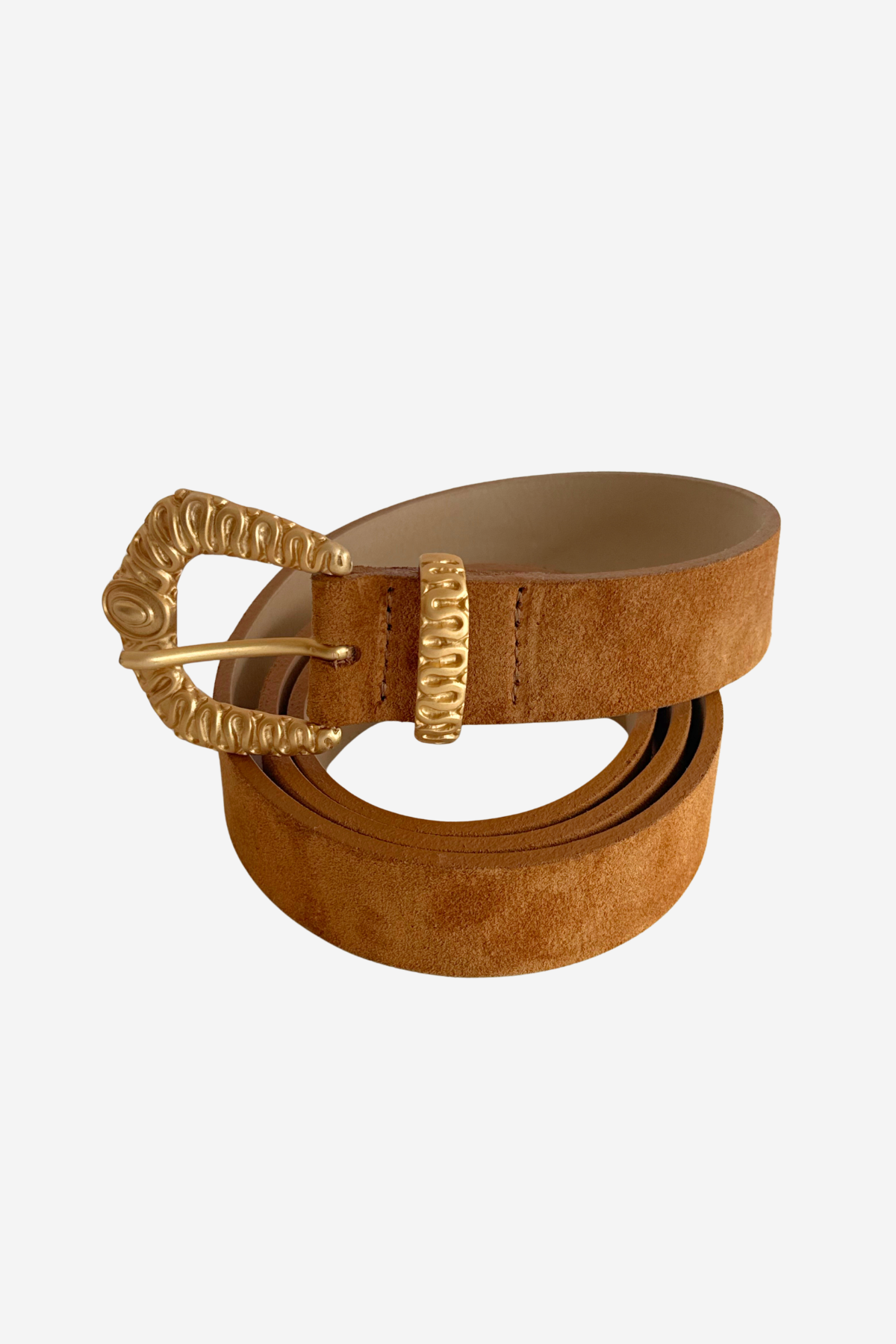 A tan suede belt with a textured gold-tone buckle and matching gold-tone keeper, coiled on a light gray background.