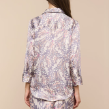 Person wearing a floral pajama set on a beige background