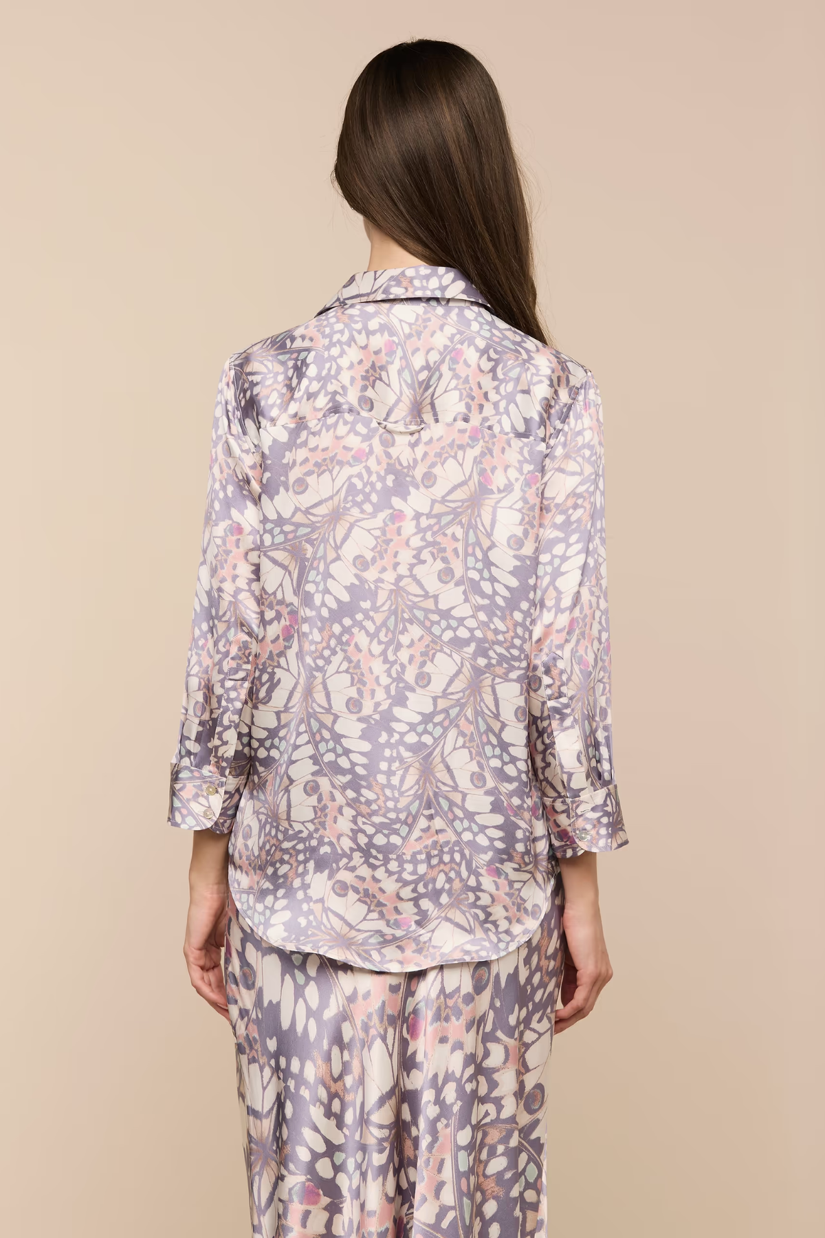 Person wearing a floral pajama set on a beige background