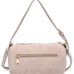 A light beige faux suede shoulder bag with a top zip closure, a front zippered pocket with a gold-tone pull, and a matching adjustable shoulder strap, shown against a plain white background.