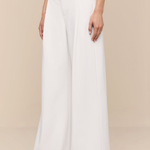 Person wearing white wide-leg pants on a beige background