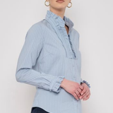 Model wearing a striped long-sleeve blouse with ruffle detailing and a relaxed, polished silhouette.