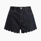 Black denim shorts with scalloped hem on a white background