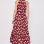 Model wearing a printed sleeveless midi dress featuring a flowing silhouette and vibrant allover pattern.